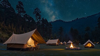 82.A peaceful camping experience in the mountains under a brilliant, starry sky, with tents set up around a roaring campfire. The Milky Way stretches across the sky above a dense forest, and the