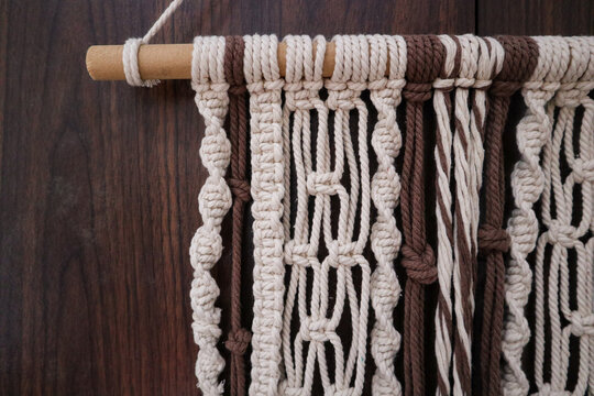 Handmade Boho Macrame Wall Hanging in Earthy Tones. A beautifully crafted macrame wall hanging featuring intricate knots in beige and brown hues. Perfect for boho, rustic, or modern home decor styles.