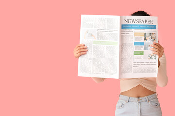 Naklejka premium Young African-American woman with newspaper on pink background