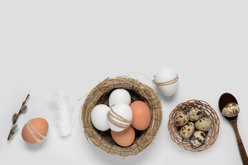 Composition with decorative nest, Easter eggs, feather and pussy willow branch on white background