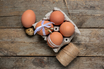 Composition with Easter eggs in holder and threads on wooden background