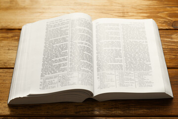 Open Holy Bible in English language on wooden table, closeup