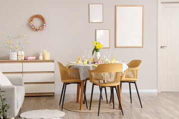 Interior of room decorated for Easter with dining table and blank frames