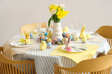 Easter table setting with tulips and chicks in room