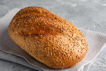 Freshly baked bread with seeds on grey table, closeup