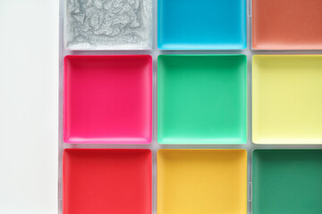 Bright face paint palette on white background, top view