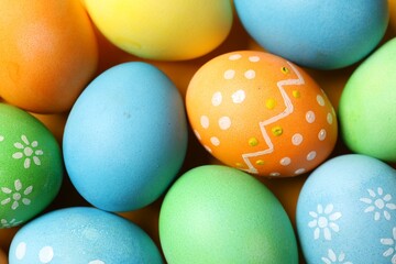 Beautiful decorated Easter eggs on orange background, flat lay