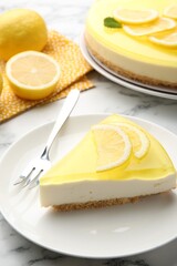 Piece of tasty lemon cheesecake and fork on white marble table, closeup