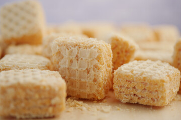 Crispy wafer squares arranged on a light wooden surface