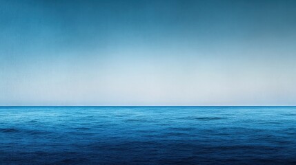 Obraz premium A cool, deep gradient background transitioning from dark blue at the top to a lighter blue at the bottom. The smooth gradient creates a calm and tranquil atmosphere, with a slight textured feel.