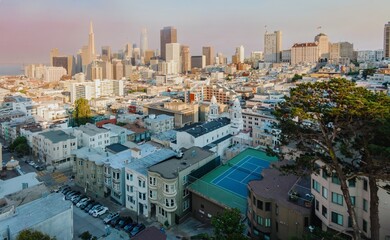San Francisco, USA: An aerial view captures the city's skyline, showcasing iconic skyscrapers like the Transamerica Pyramid. Residential buildings and a tennis court add to the urban landscape.