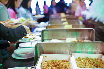 Group of business people hand grab some buffet self service food on their own plate