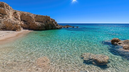 Fototapeta premium Crystal Clear Water Reflecting Sunshine on Serene Beach Surrounded by Rocky Shore Near a Tropical Oasis under a Bright Blue Sky
