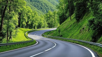 Fototapeta premium Curvy Winding Road Through Lush Green Forest Landscape Surrounded by Mountains in a Bright Summer Day