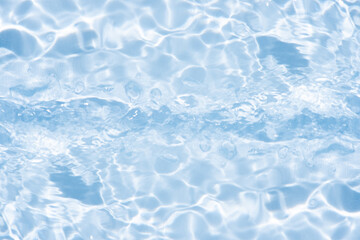 Blue water with ripples on the surface. Defocus blurred transparent blue colored clear calm water surface texture with splashes and bubbles. Water waves with shining pattern texture background.