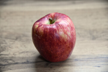 Plate with apples and autumn leaves on wooden table