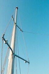 Obraz premium A Tall Ship's Mast and Rigging Against a Vivid Azure Sky, Showing Intricate Details of Sailing Equipment