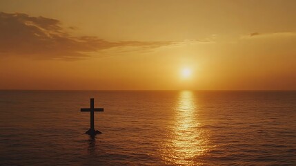 Silhouette cross in ocean at sunset.