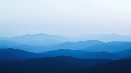 Serene blue mountain range at dawn, layered peaks fading into mist.
