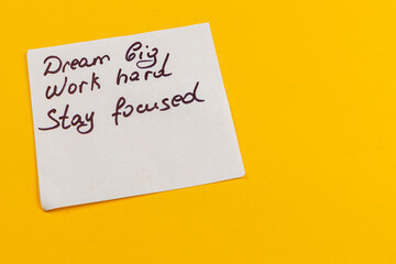 Motivational note on yellow background encouraging dedication and focus