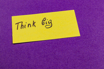 Motivational message on a bright yellow note against purple background