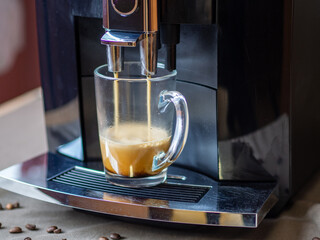 Coffee machine makes coffee. Aromatic coffee in the morning in a glass mug. Breakfast or lunch drink. Choosing a quality coffee machine