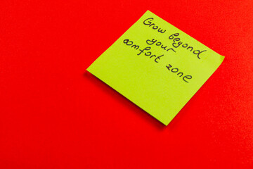 Sticky note encouraging personal growth on a vibrant red background