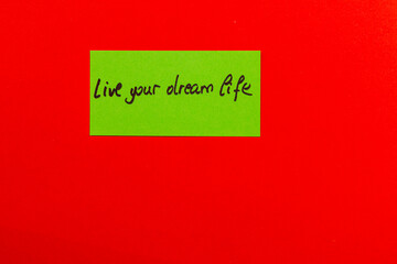 Inspiring note on colorful background encouraging you to live your dream life