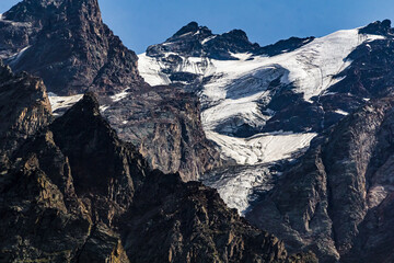 Glacier melting on mountain peaks under blue sky