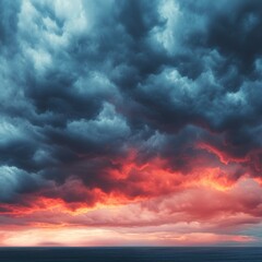 Obraz premium Dramatic sky with dark clouds and vibrant red sunset over the ocean creating a powerful and atmospheric seascape for backgrounds