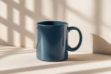 Obraz premium Elegant dark blue ceramic mug on a neutral background with soft sunlight and grid-like shadows. Ideal for branding, product presentations, and promotional designs