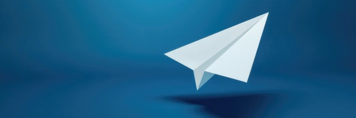 White paper plane suspended in the air on a dark blue background, plane, tranquil, atmosphere