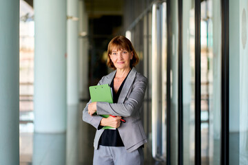 Fototapeta premium Senior businesswoman in gray suit portriat on company corridor for business career path concept.