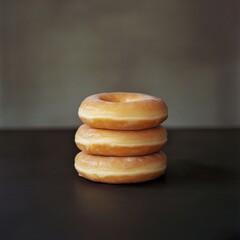 three donuts stacked on dark background