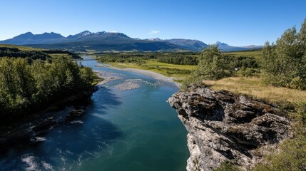A river winds through a lush valley under a bright sky, surrounded by forest and distant mountains, creating a picturesque and tranquil scene.