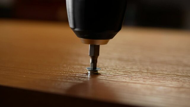 screwdriver driving a screw into wood, Furniture assembly