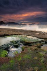 Sunset with a sky with dramatic clouds on the beach of Tunelboca on the cliffs of La Galea, Getxo, Bizkaia