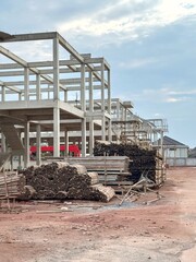 Reinforced steel and concrete building under construction, lumber pilling up