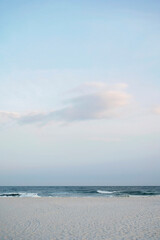 Serene beach scene with soft waves, sandy shore, and pastel sky