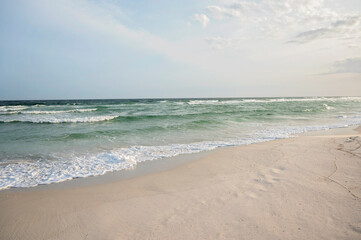 Fototapeta premium Serene beach with gentle ocean waves rolling onto the sandy shore