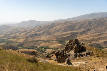 A rocky hillside with a clear blue sky in the background