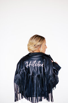 Bride in a black fringe leather jacket with "Hitched" lettering,