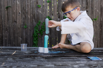 Young boy in goggles conducting a science experiment on sunny day