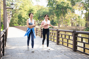 Fitness, woman and friends running in the park for cardio exercise, training or workout together in the outdoors. Happy active women enjoying a run for a healthy balanced lifestyle .