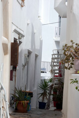 Narrow alley leading to steps and old wooden door in greek islands