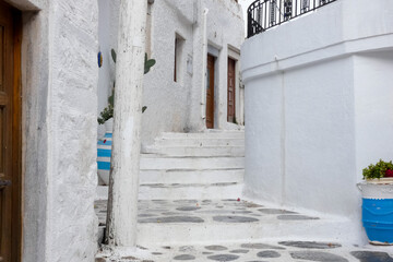 Whitewashed alley with stairs leading upwards in greek islands