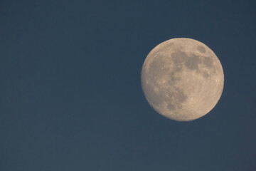 Crescent moon shining in the blue sky during the day