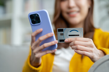 Asian woman using credit card.Happy cheerful girl enjoying online shopping,using ecommerce app on smartphone,paying for purchase, order by credit card,buying goods on Internet.online shopping concept.