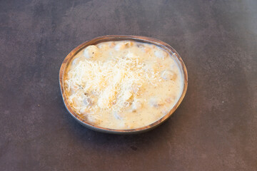 A bowl of creamy soup with cheese on top