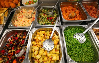 steel trays with vegetables and first courses in the self-service restaurant ideal for lunch break in the company or school canteen